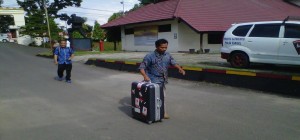 Salah satu petugas KPK membawa koper besar hasil penggeledahan. RMOLSumsel