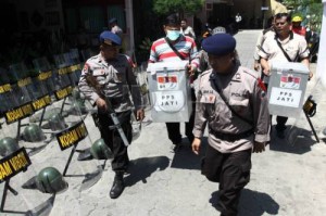Polisi bersenjata mengawal panitia pemilihan kecamatan (PPK) membawa kotak suara di Kecamatan Mayangan, Kota Probolinggo, Jawa Timur, Sabtu (31/8). Penjagaan ketat dari petugas kepolisian tersebut sebagai antisipasi dari aksi anarkis massa yang dipicu oleh adanya dugaan pelanggaran tidak tersegelnya kotak suara saat proses penghitungan suara Pilkada Kota Probolinggo