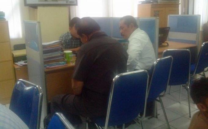 Mantan Sekda Palembang, Marwan Hasmen (berbaju putih) saat berada di Polresta Palembang menjalani pemeriksaan atas dugaan penyerobotan tanah.